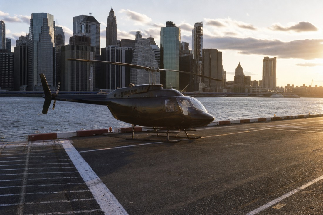 Sightseeing helicopter on a riverside Manhattan helipad at golden hour